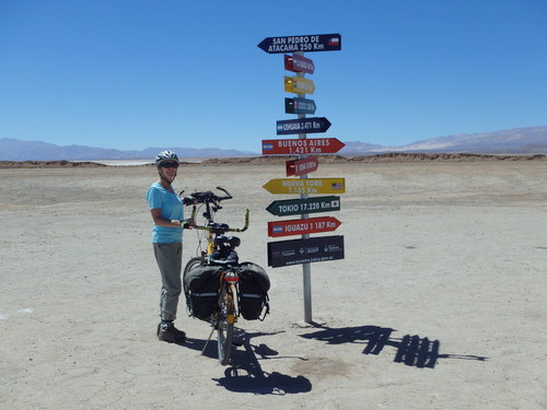 Terry Struck and the Bee with City Name, Distance, and Direction Signs at Salinas Grandes.
